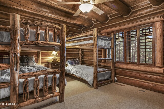 bedroom with carpet flooring, ceiling fan, beam ceiling, and wooden ceiling