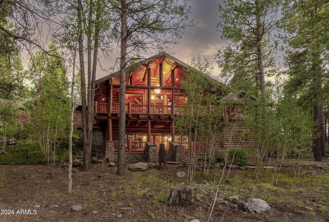 back house at dusk featuring a deck