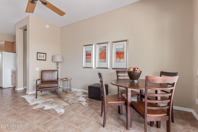 dining area featuring a ceiling fan, baseboards, and light tile patterned floors