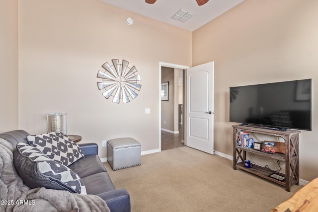 carpeted living room with baseboards, visible vents, and a ceiling fan