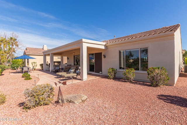 rear view of house featuring a tiled roof, a patio area, a ceiling fan, and stucco siding