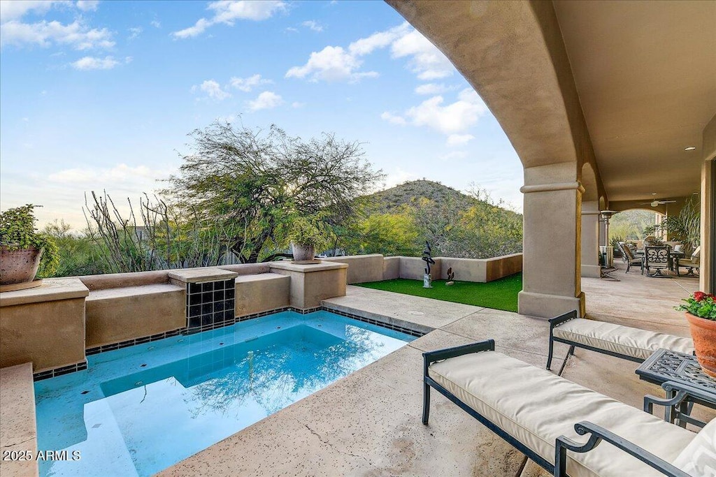 view of swimming pool with a mountain view and a patio area