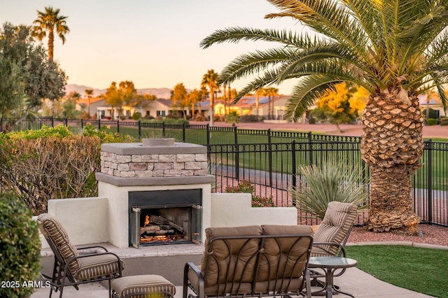 patio terrace at dusk with an outdoor stone fireplace