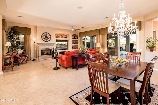 dining area with ceiling fan with notable chandelier, light tile patterned floors, and built in shelves