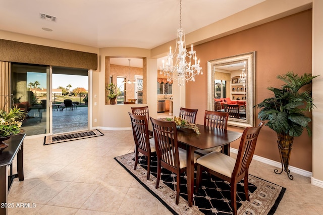 tiled dining area featuring an inviting chandelier