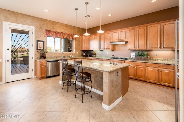 kitchen with dishwasher, an island with sink, a kitchen breakfast bar, hanging light fixtures, and light stone countertops