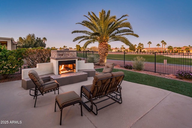 patio terrace at dusk with an outdoor stone fireplace