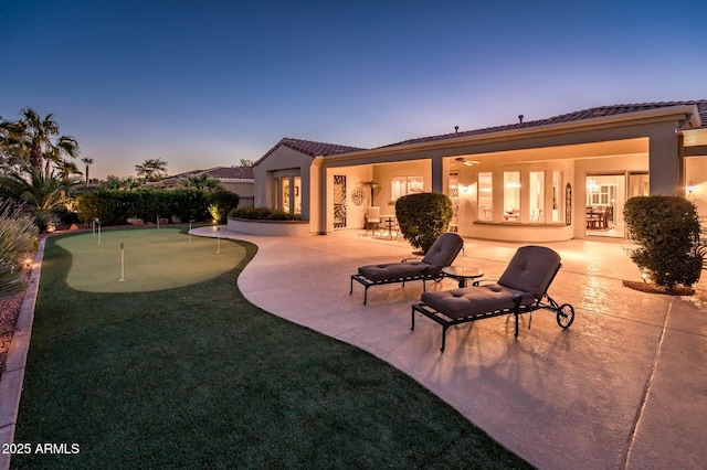 back house at dusk with a patio