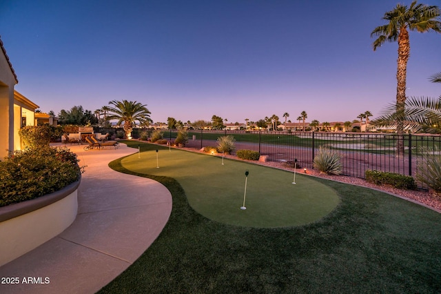 yard at dusk featuring a patio and a water view