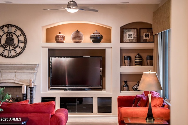 living room with built in features and ceiling fan