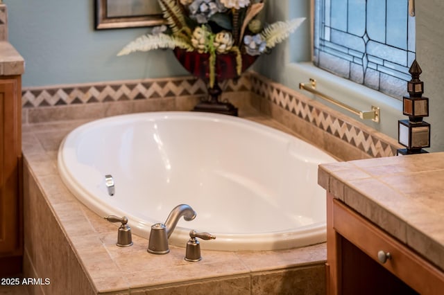 bathroom with vanity and a relaxing tiled tub