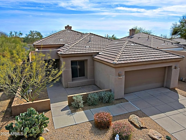view of front of home with a chimney, stucco siding, a tiled roof, and an attached garage