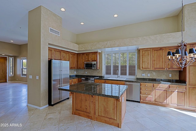 kitchen featuring visible vents, tile countertops, a sink, high quality appliances, and an inviting chandelier