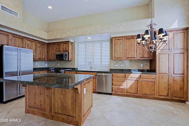 kitchen featuring decorative backsplash, visible vents, appliances with stainless steel finishes, a sink, and an inviting chandelier
