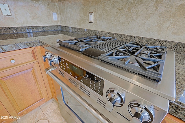 details featuring stainless steel gas range oven and tile countertops