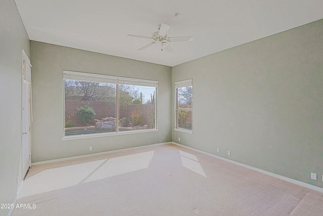 spare room featuring baseboards, a ceiling fan, and carpet