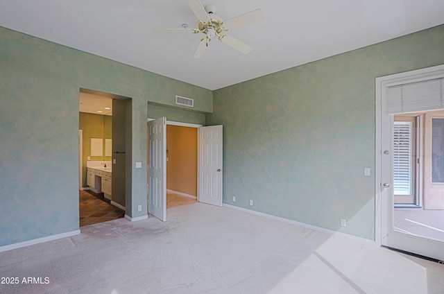 unfurnished bedroom with carpet floors, ensuite bathroom, baseboards, visible vents, and ceiling fan