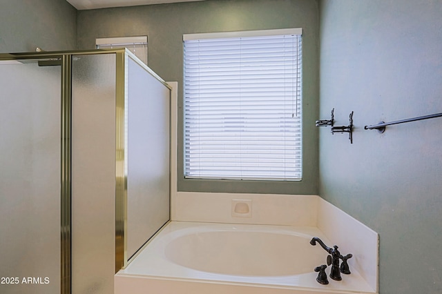 full bathroom featuring a garden tub and a shower stall