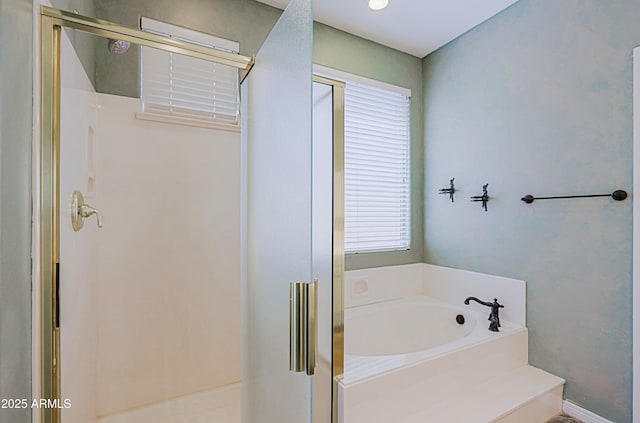 bathroom featuring a garden tub and a shower stall