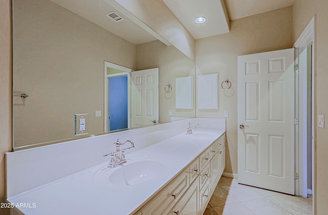 bathroom with tile patterned floors, a sink, double vanity, and visible vents