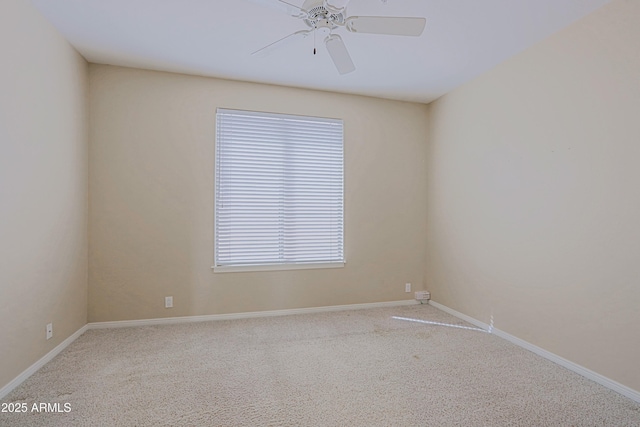 carpeted spare room with a ceiling fan and baseboards