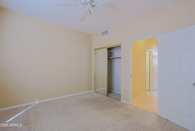 unfurnished bedroom featuring light colored carpet, visible vents, a closet, and baseboards