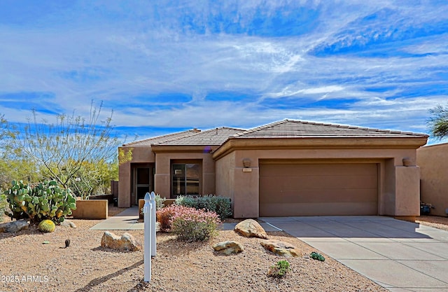 view of front of home featuring driveway, stucco siding, a tile roof, and a garage