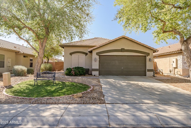 view of front of property with stucco siding, a garage, driveway, and a tile roof