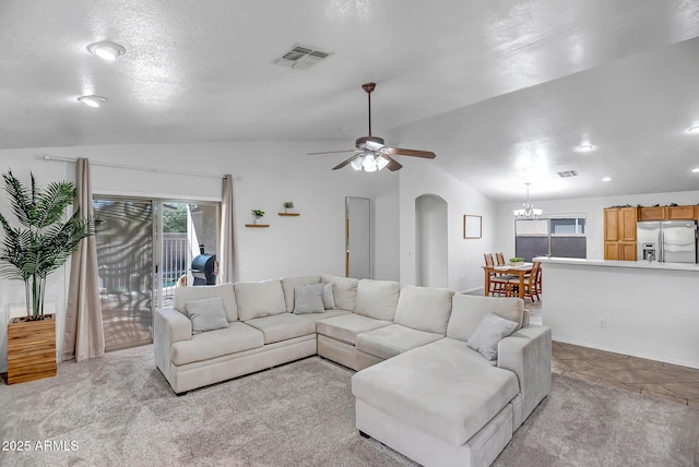 living area featuring light colored carpet, lofted ceiling, arched walkways, and visible vents