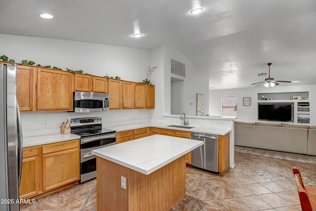 kitchen featuring open floor plan, light countertops, a peninsula, stainless steel appliances, and a sink