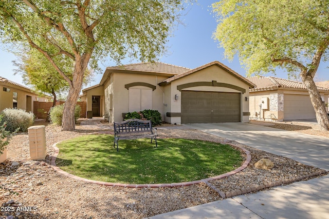 view of front facade with concrete driveway, a tiled roof, an attached garage, and stucco siding