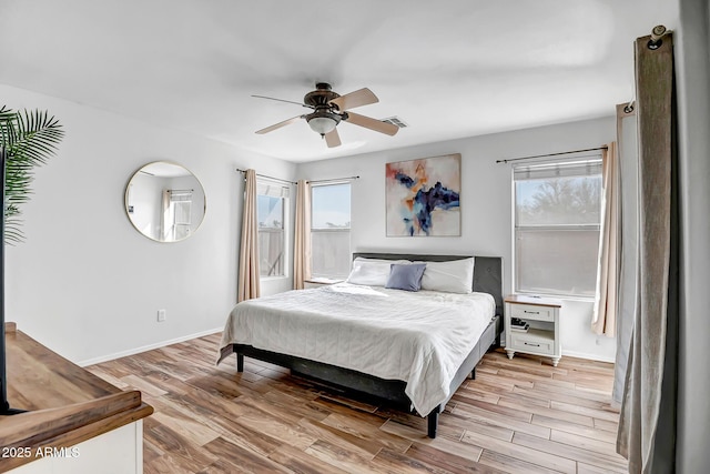 bedroom with ceiling fan, visible vents, baseboards, and light wood-style flooring