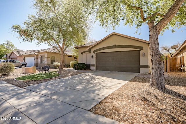 view of front of home featuring fence, an attached garage, stucco siding, concrete driveway, and a tiled roof