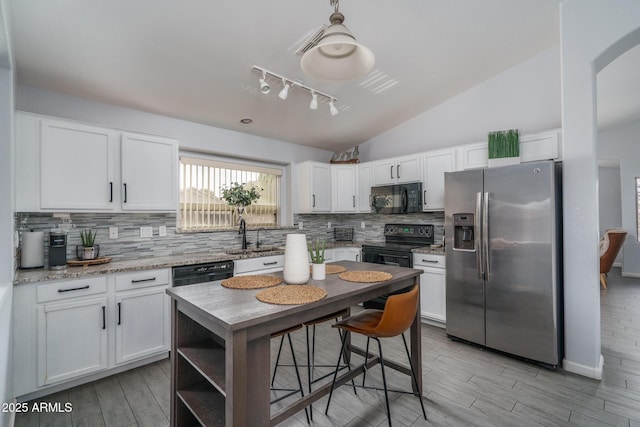 2889 S 161st Dr, Goodyear, AZ 85338 - kitchen with lofted ceiling, a sink, black appliances, white cabinetry, and backsplash