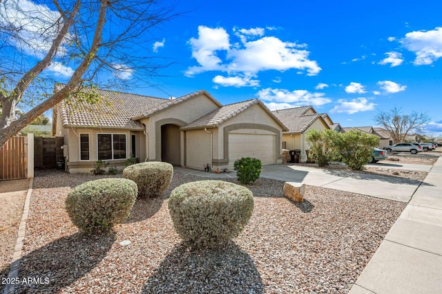 view of front of home featuring a tile roof, stucco siding, concrete driveway, an attached garage, and fence