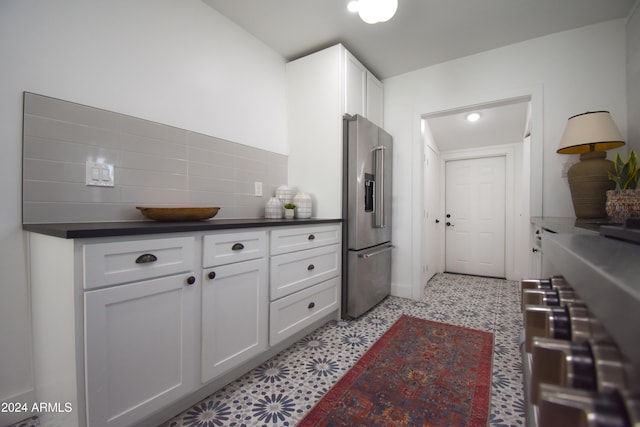 kitchen with high end refrigerator, white cabinets, and decorative backsplash