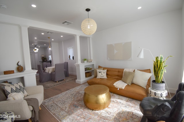 living room featuring ornate columns and wood-type flooring