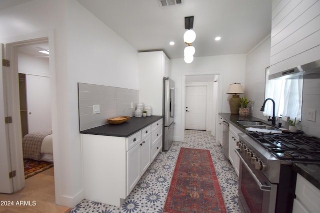 kitchen featuring appliances with stainless steel finishes, decorative backsplash, white cabinets, and sink