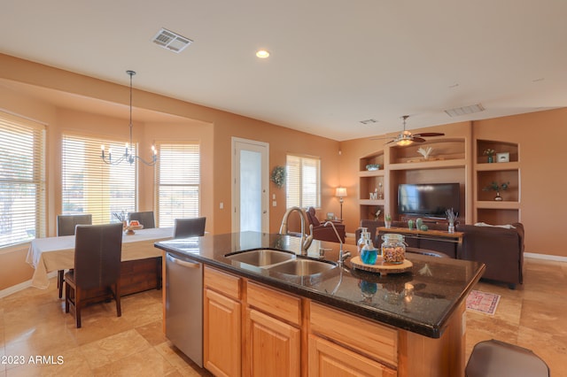 kitchen featuring ceiling fan with notable chandelier, a kitchen island with sink, sink, pendant lighting, and dishwasher