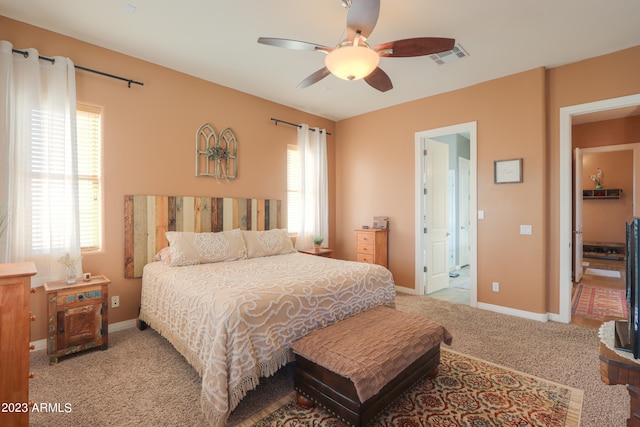 bedroom featuring multiple windows, light colored carpet, and ceiling fan