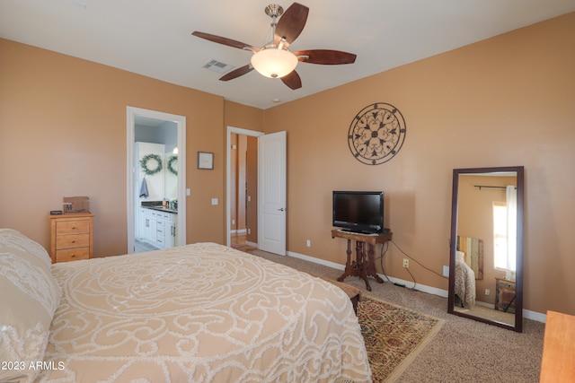 bedroom with ensuite bathroom, ceiling fan, and light colored carpet