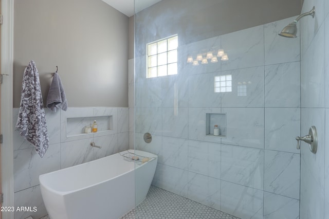 bathroom with a washtub, tile patterned flooring, and tile walls