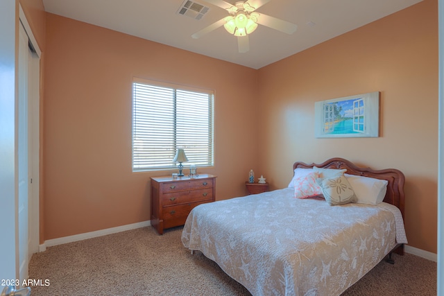 bedroom with ceiling fan, light colored carpet, and a closet