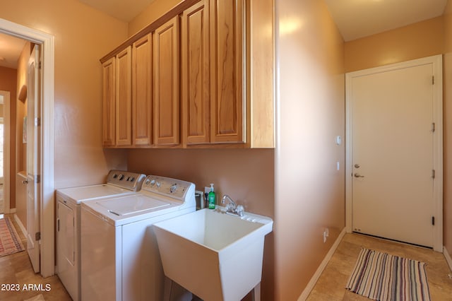 clothes washing area featuring cabinets, light tile patterned floors, sink, and washing machine and clothes dryer