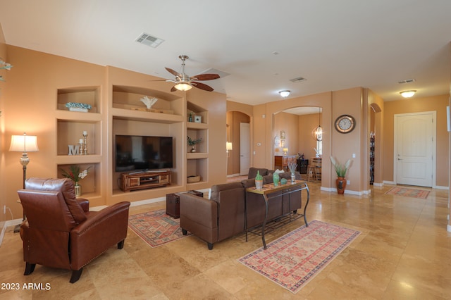 living room featuring built in shelves and ceiling fan