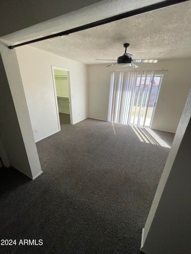 empty room featuring carpet, a textured ceiling, and ceiling fan