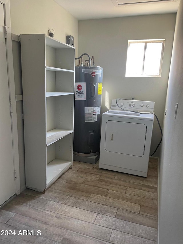 clothes washing area with water heater, light hardwood / wood-style flooring, and washer / dryer