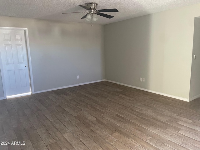 empty room featuring ceiling fan, dark hardwood / wood-style floors, and a textured ceiling