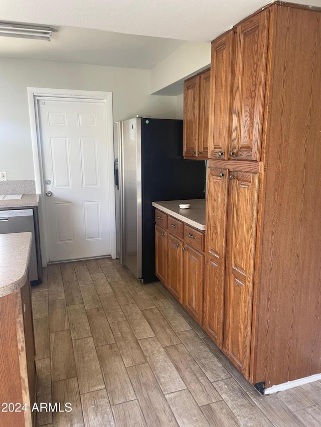 kitchen with appliances with stainless steel finishes and light hardwood / wood-style flooring