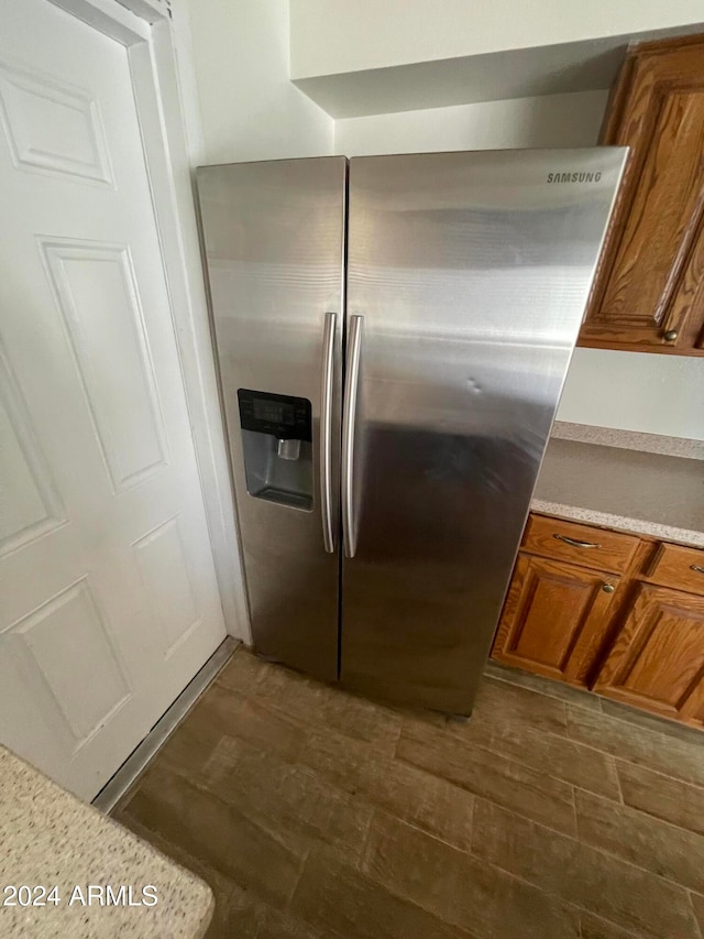 kitchen with dark wood-type flooring and stainless steel fridge